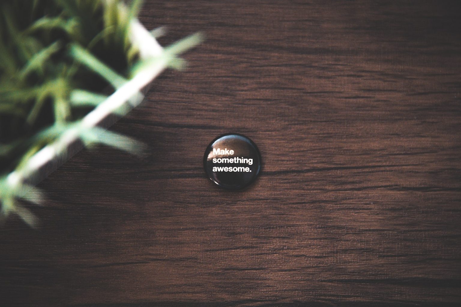 Comment le pin’s personnalisé peut améliorer votre entreprise ? round black button pin on brown wooden surface