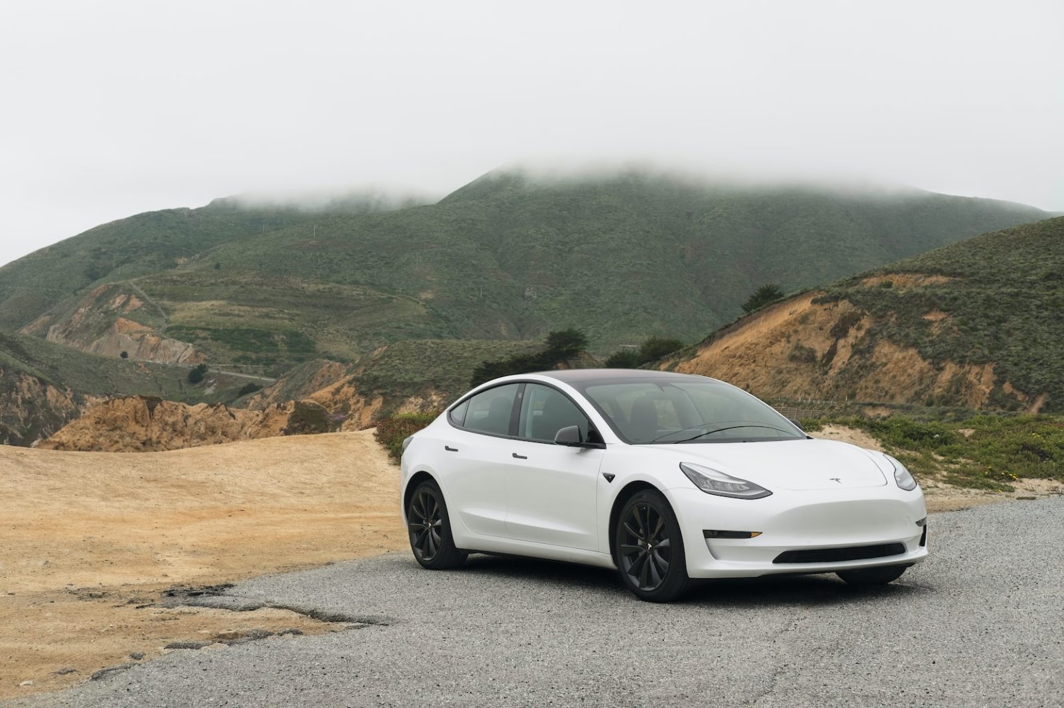 Voiture électrique 2024 : les avantages et les désavantages de l’électrification de la mobilité white sedan parked beside mountain during daytime