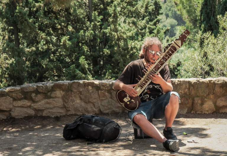 man holding string instrument during daytime