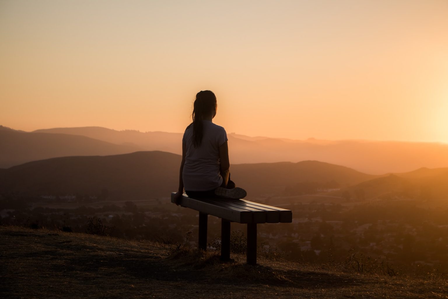 5 applications de méditation pour retrouver votre zen au quotidien woman sitting on bench over viewing mountain