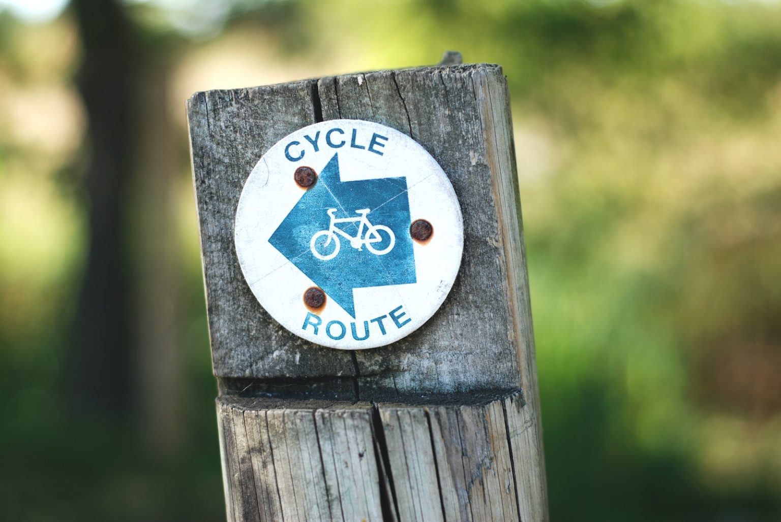 7 conseils pour préserver l’environnement lors d’un séjour en montagne en été cycle route sign on a wooden post