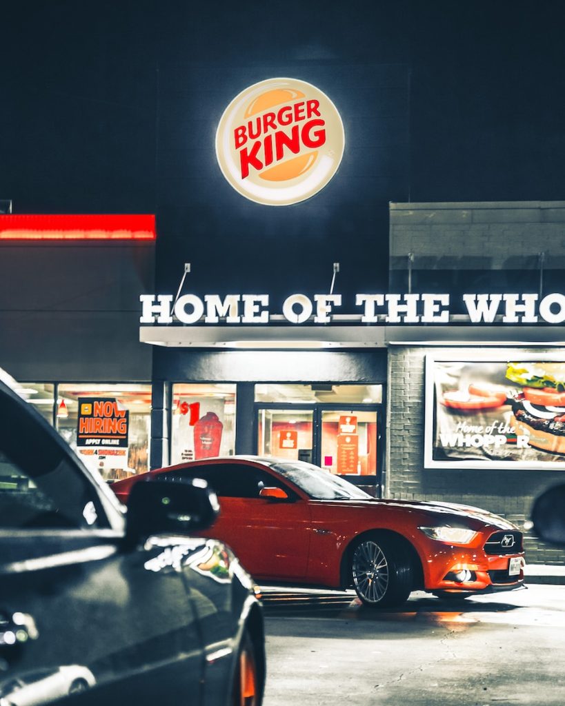 a burger king restaurant with cars parked in front of it