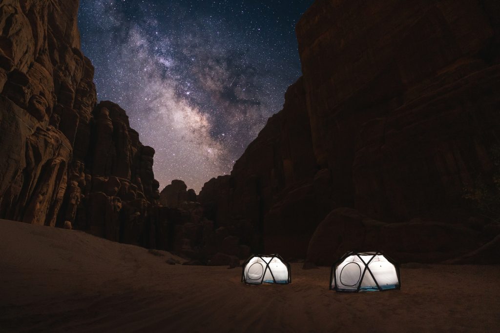 two tents set up in the desert under a night sky