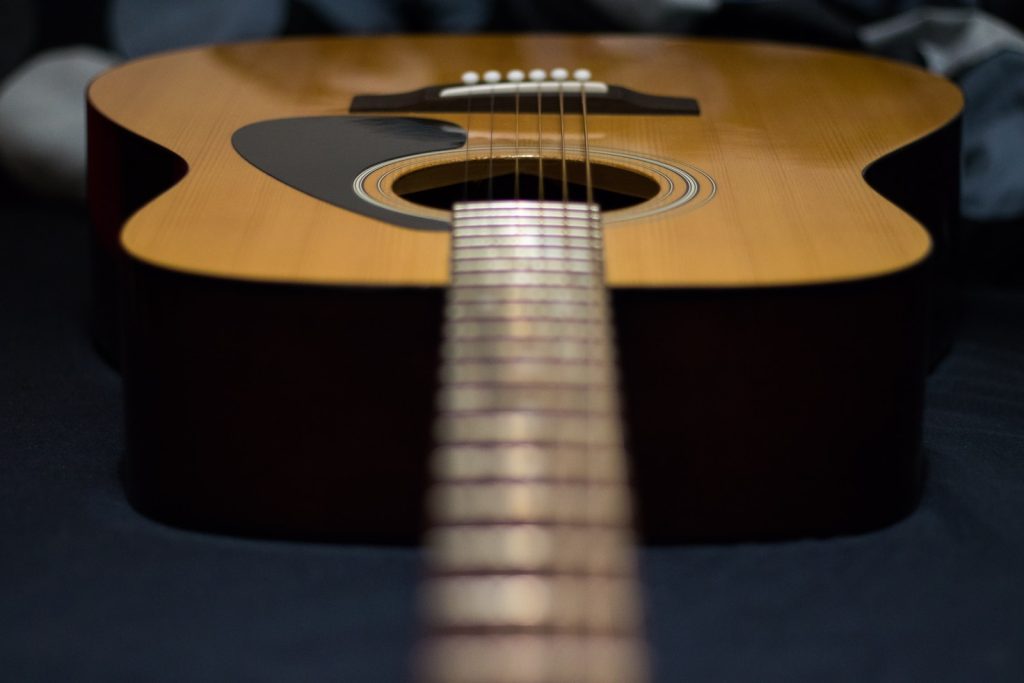 tilt-shift photography of brown acoustic guitar