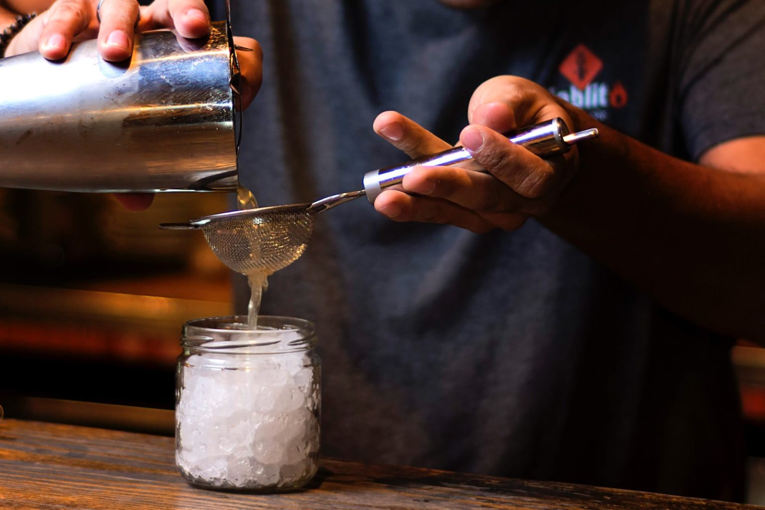 Qu’est-ce-que la Mixologie ? Le dictionnaire de Votre Barman ! person pouring water on stainless steel cup