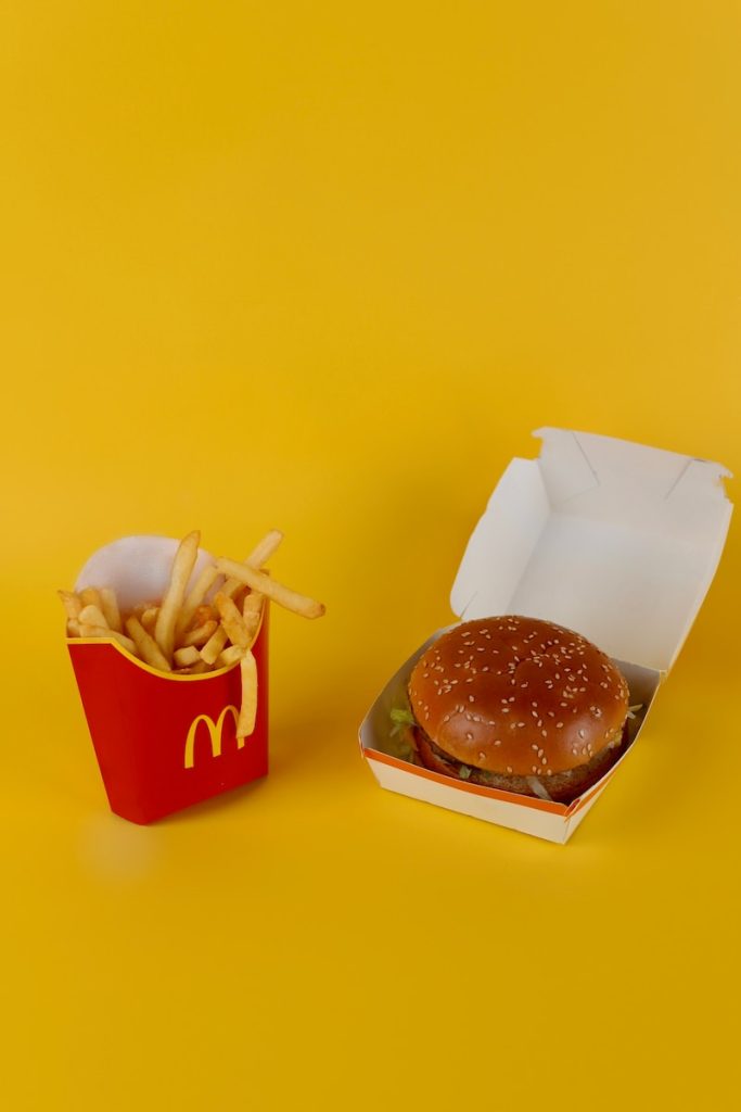 a mcdonald's hamburger and french fries on a yellow background
