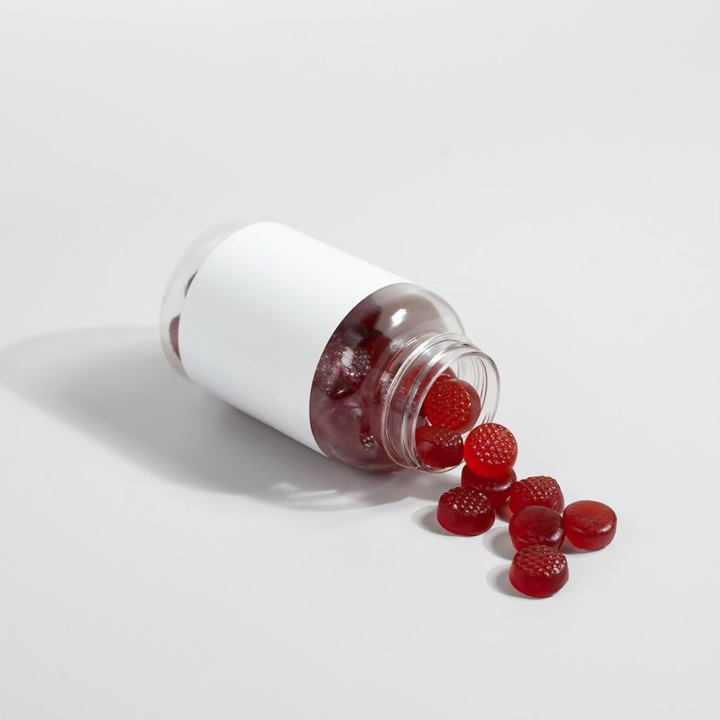 a white salt shaker with red berries