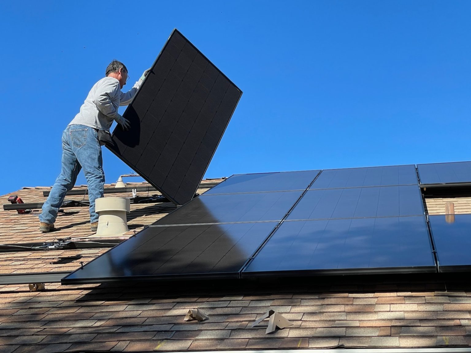 Où acheter un panneau solaire ? man in white dress shirt and blue denim jeans sitting on white and black solar panel
