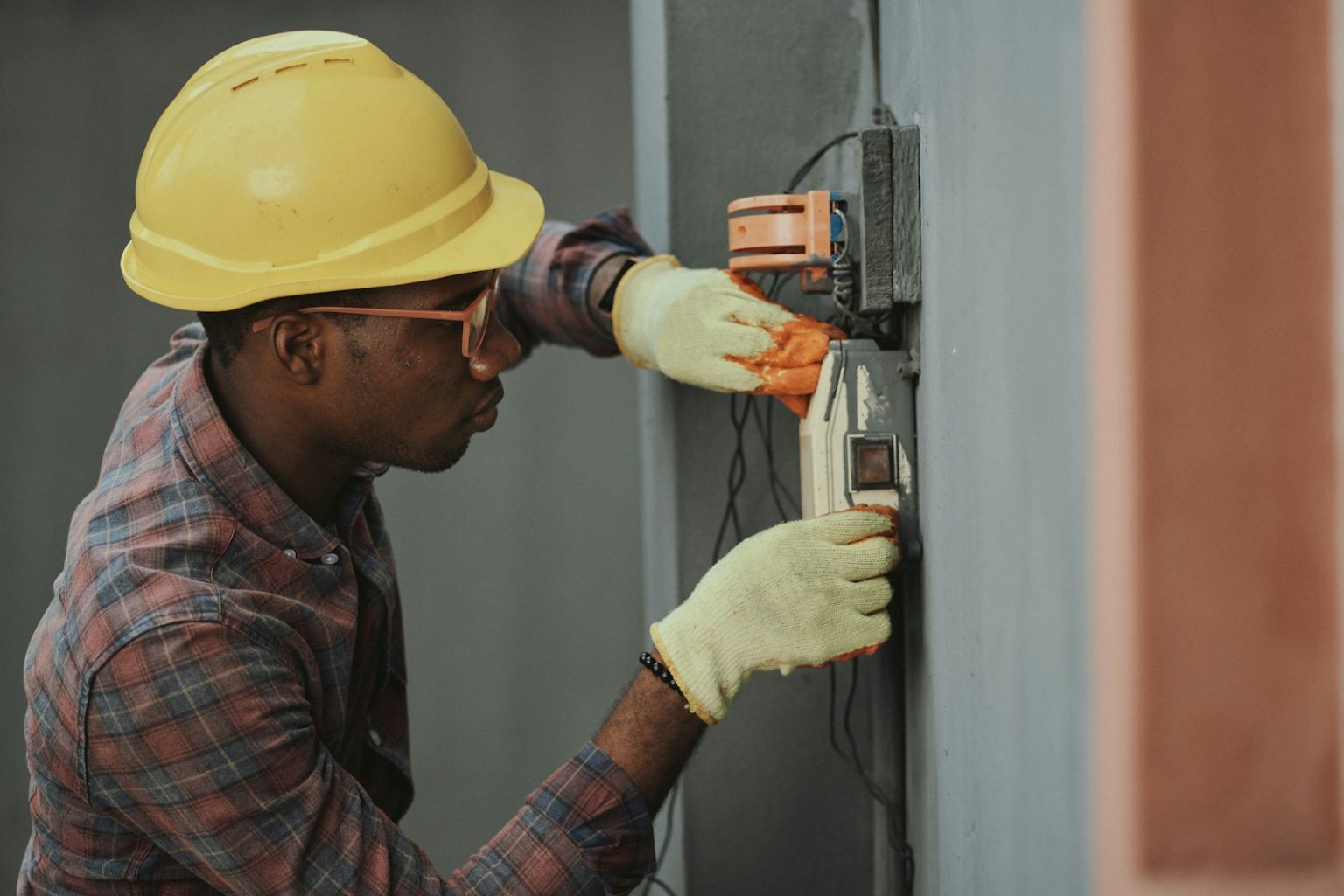 Comment choisir le bon électricien pour vos travaux d’électricité ? man in brown hat holding black and gray power tool
