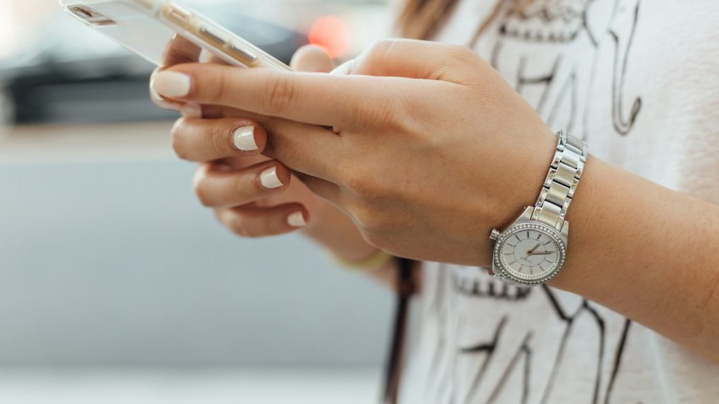 woman holding iPhone during daytime